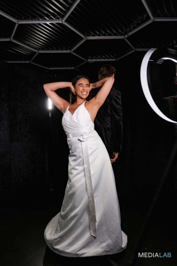 Bride and groom taking a photo on a 360 photo booth black themed