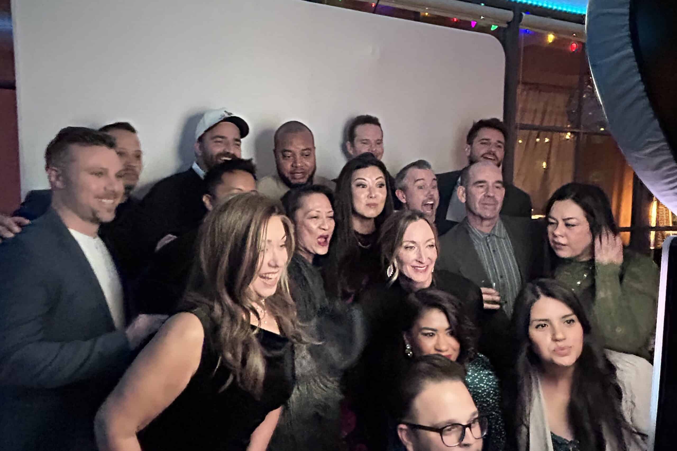 A large group of friends taking an image with a photo booth