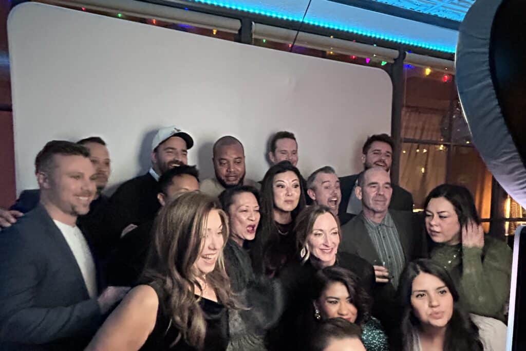 A large group of friends taking an image with a photo booth