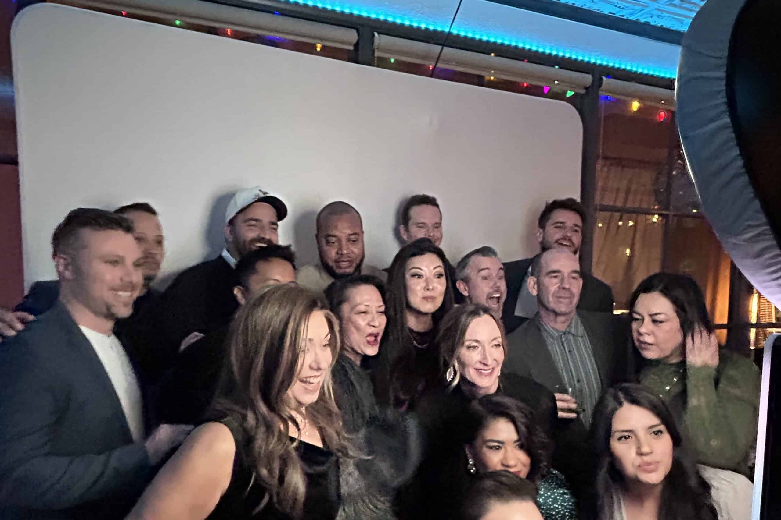 A large group of friends taking an image with a photo booth