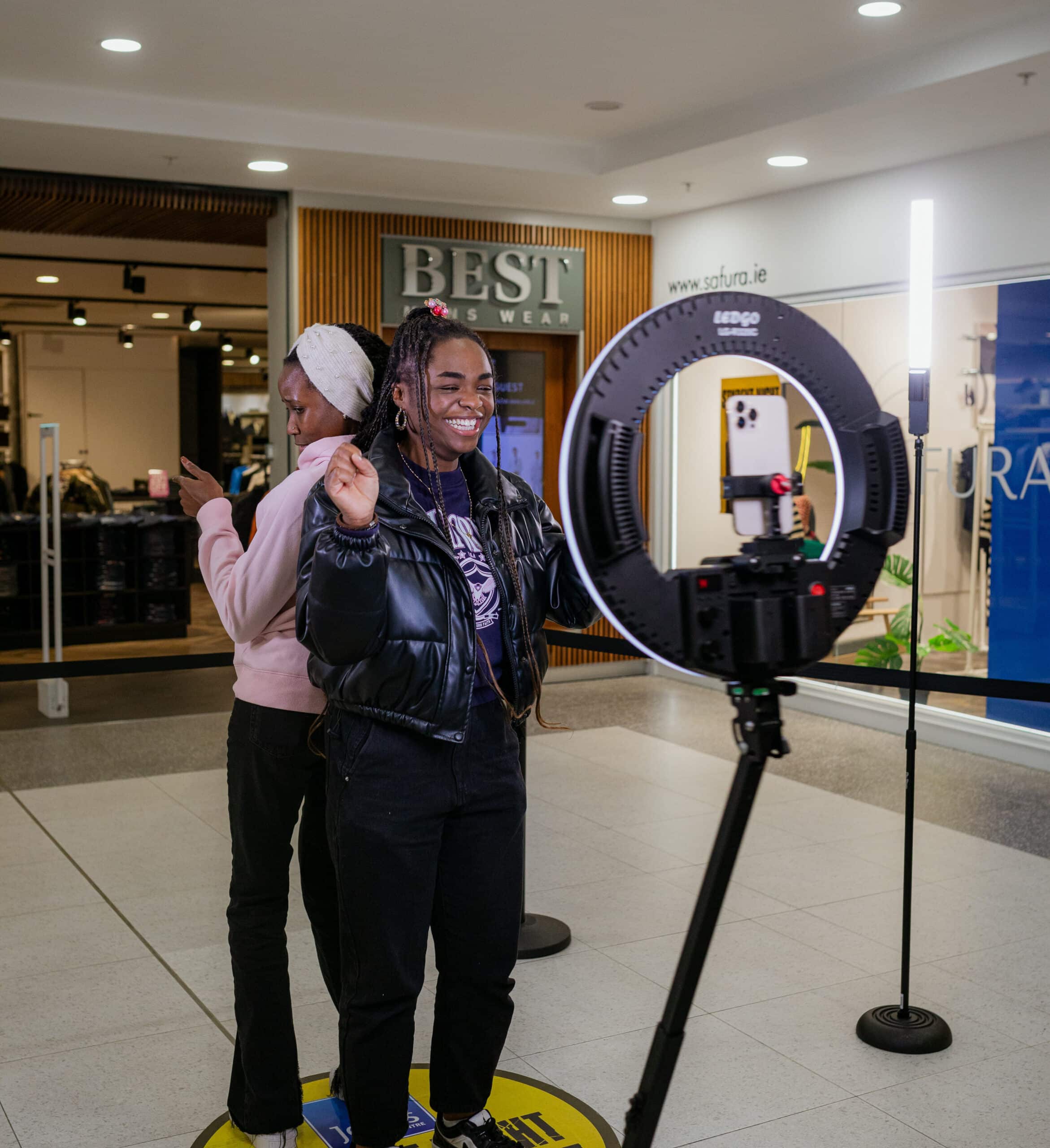 Two woman taking a short video in a 360 photo booth